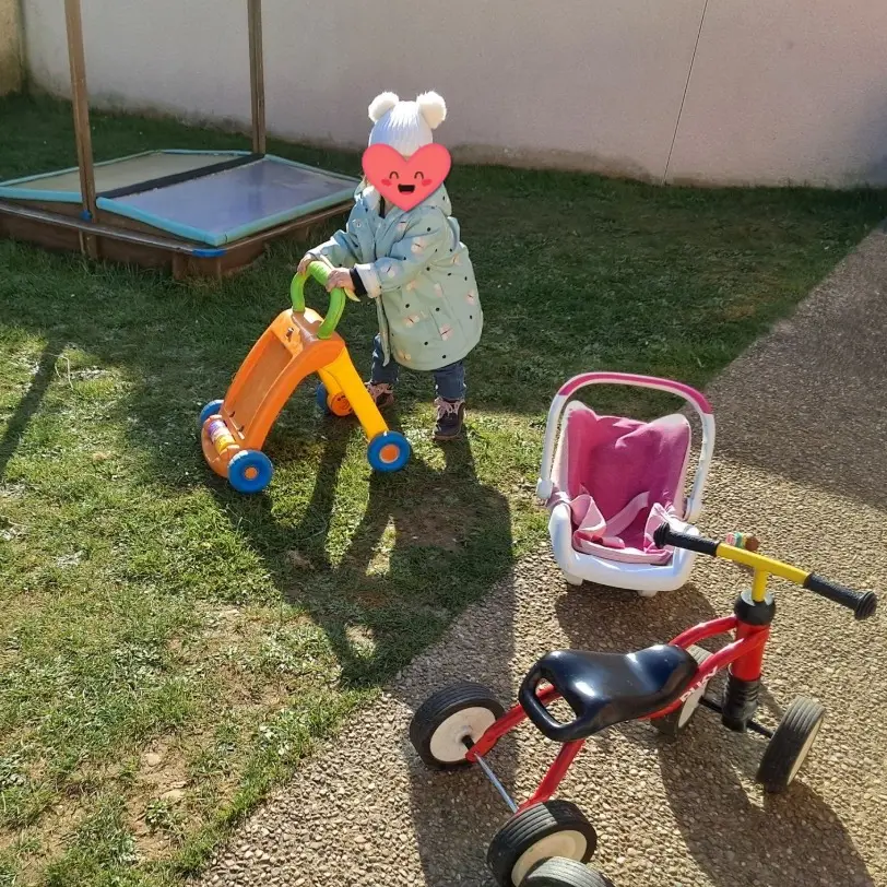 Une fillette joue dans le jardin de la crèche
